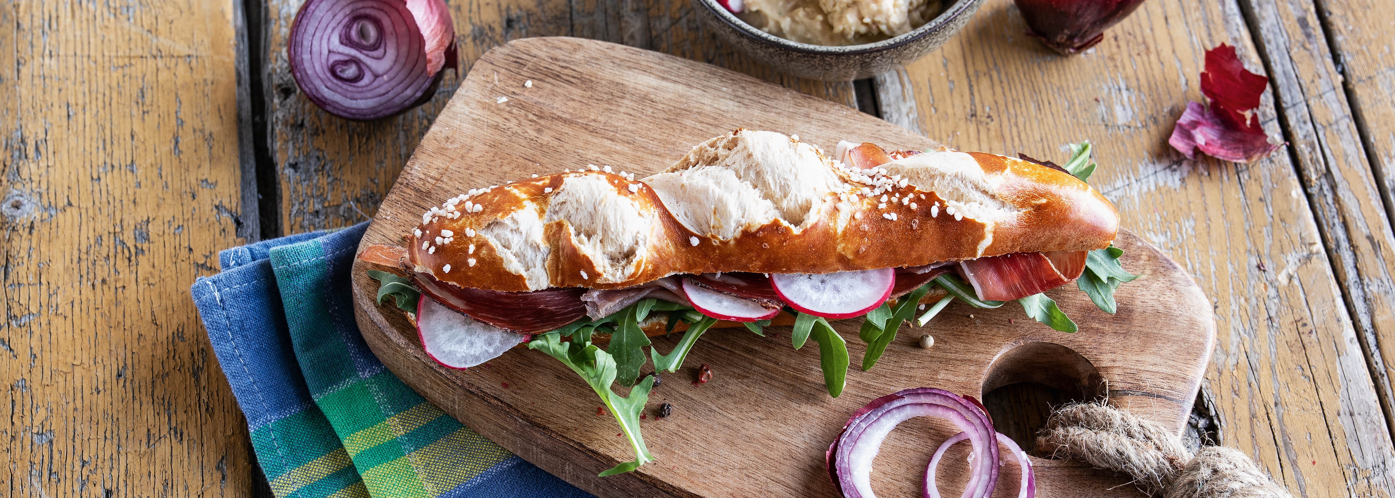 Laugen-Sandwich mit Rucola, Schinken und Radieschen
