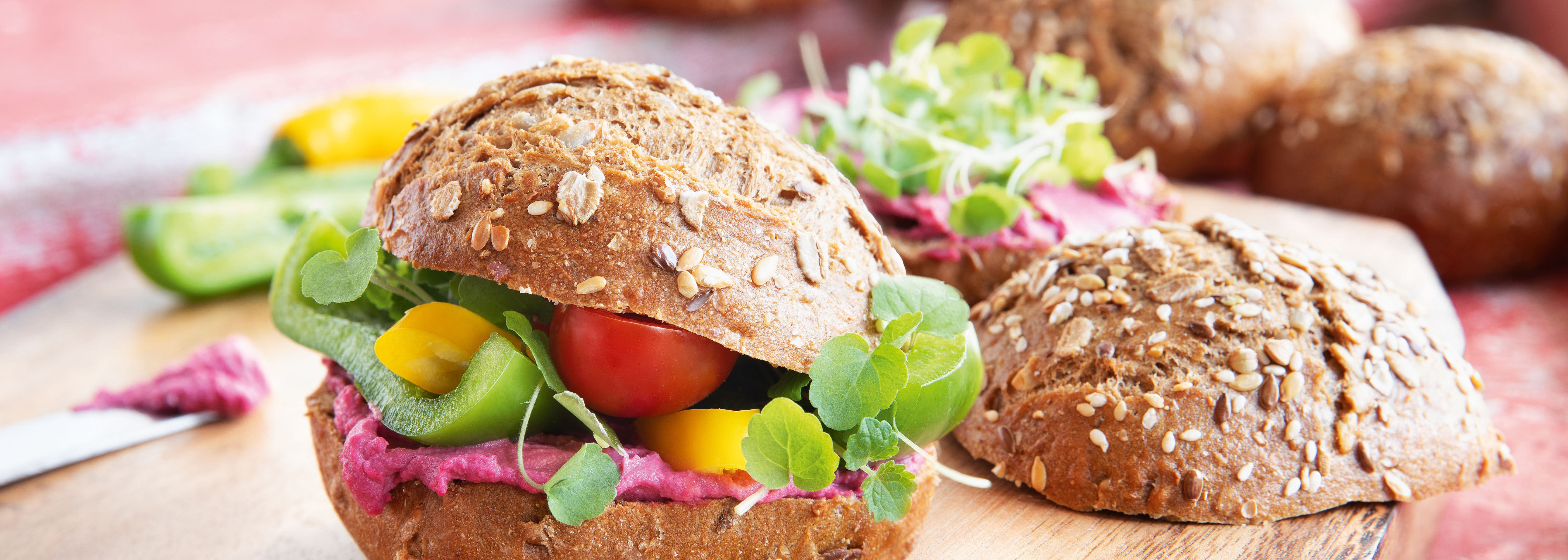 King-Sandwich mit rotem Hummus, Paprika, Tomaten und Brunnenkresse