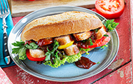 BBQ-Sandwich mit Grillwurst, Tomaten und Paprika